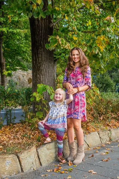 Porträt einer glücklichen Mutter und eines kleinen Mädchens im Stadtpark — Stockfoto