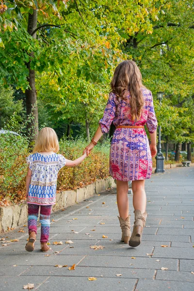 Mother and baby girl walking in city park. rear view — Stock Photo, Image