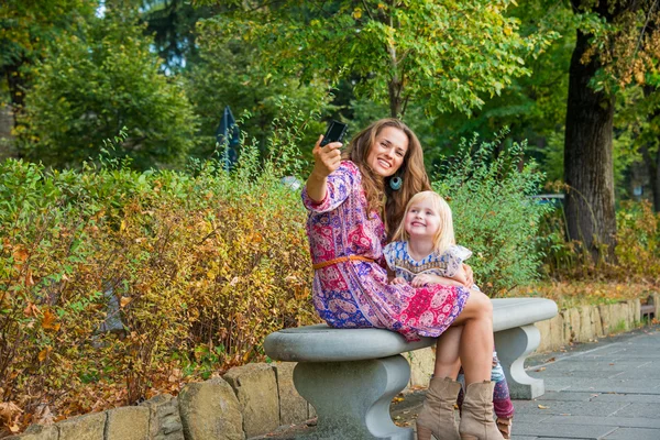 Mother and baby girl making selfie in city park — Stock Photo, Image