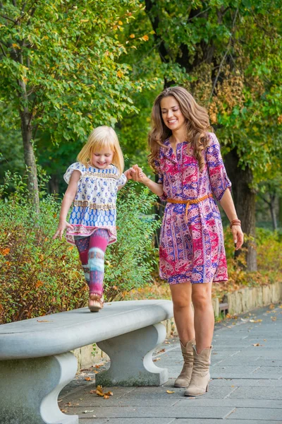 Happy mother and baby girl having fun time in city park — Stock Photo, Image