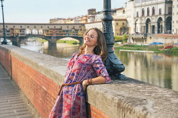 Relaxed young woman on embankment near ponte vecchio in florence — Stock Photo, Image