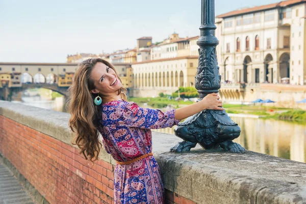 Glad ung kvinna på vallen nära ponte vecchio i Florens, — Stockfoto