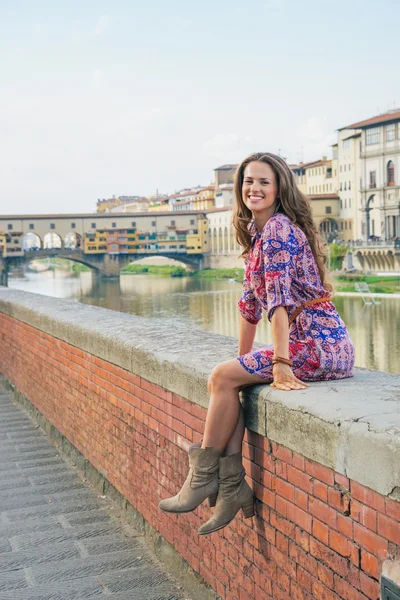 Jovem feliz sentada perto de ponte vecchio em florence, itália — Fotografia de Stock