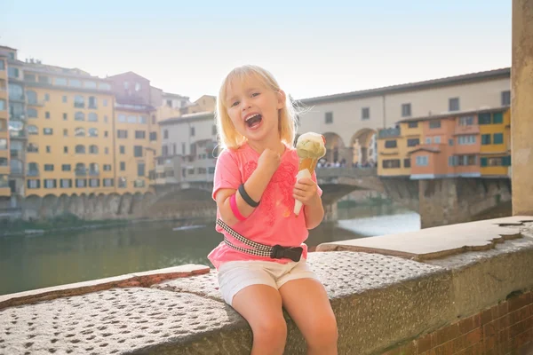 Happy baby girl eating ice cream near ponte vecchio in florence, — Stock Photo, Image