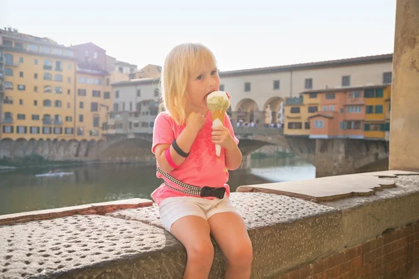 ヴェッキオ橋近くのアイスクリームを食べて幸せな赤ちゃん少女の肖像画 — ストック写真