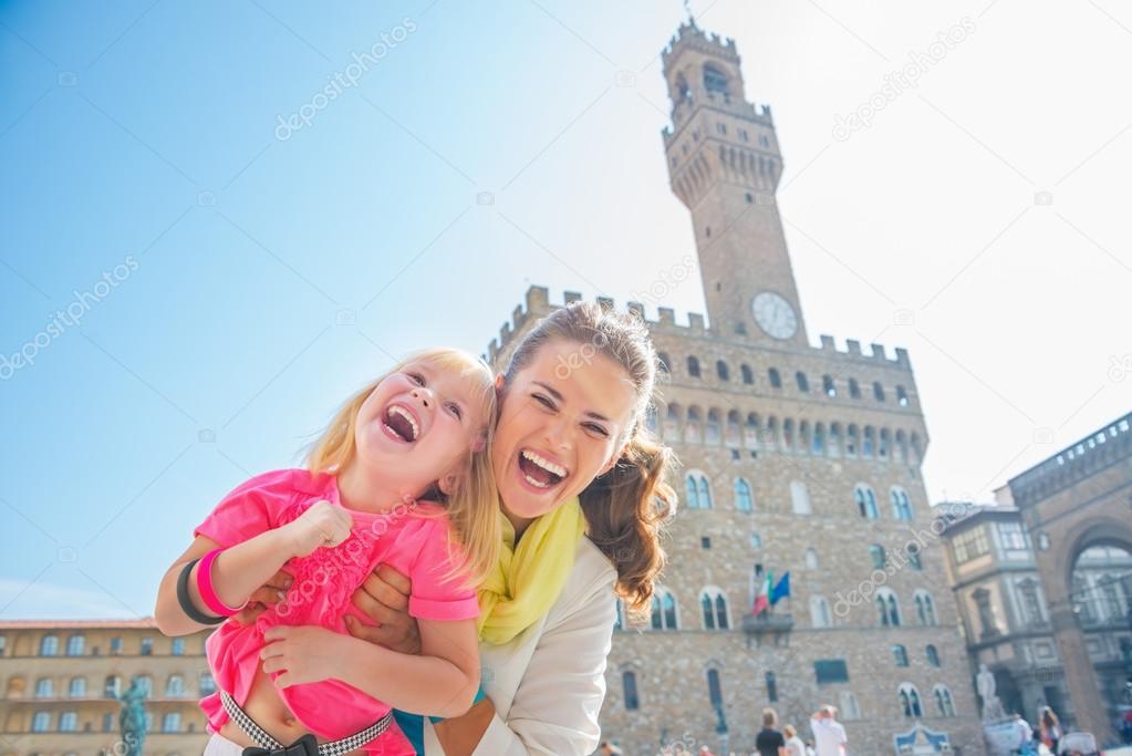 Portrait of happy mother and baby girl in front of palazzo vecch