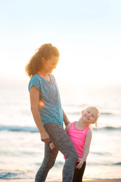 Gesunde Mutter und kleines Mädchen am Abend am Strand — Stockfoto
