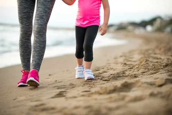 Zdrowa matka i dziecko dziewczyna spaceru na plaży wieczorem — Zdjęcie stockowe