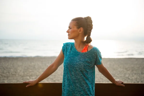 Portret van de jonge vrouw fitness op strand in de avond — Stockfoto