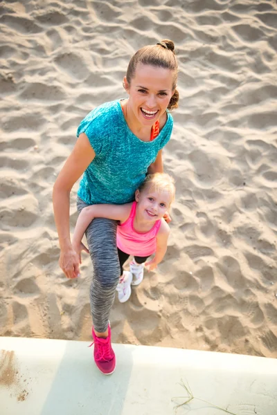 Porträt einer gesunden Mutter und eines kleinen Mädchens am Strand — Stockfoto