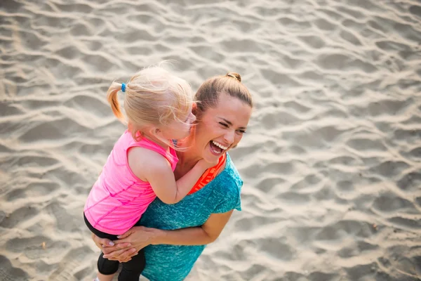 Frisk mamma och baby flicka på stranden har kul tid — Stockfoto