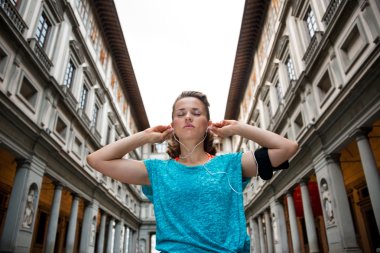 Floransa'da uffizi gallery yakınındaki kulaklık giyen fitness kadın,