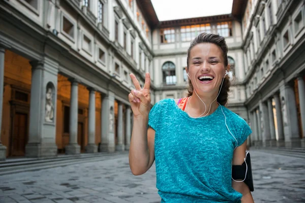 Mujer fitness feliz mostrando el gesto de victoria cerca de la galería uffizi —  Fotos de Stock