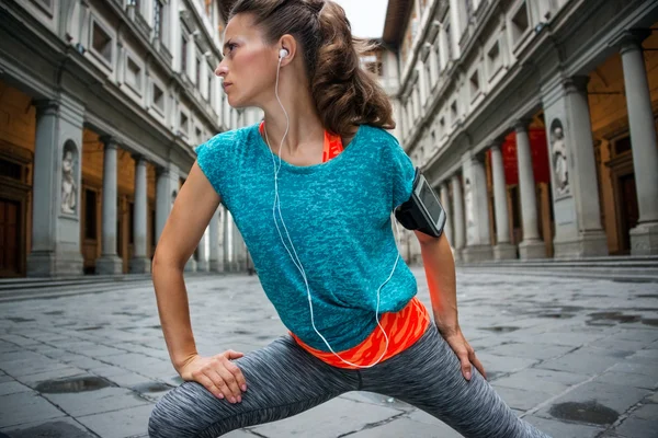 Fitness vrouw die zich uitstrekt in de buurt van uffizi galerij in florence, Italië — Stockfoto