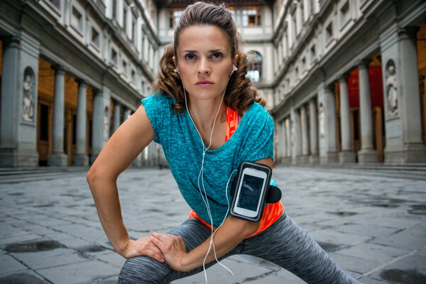 Fitness woman stretching near uffizi gallery in florence, italy