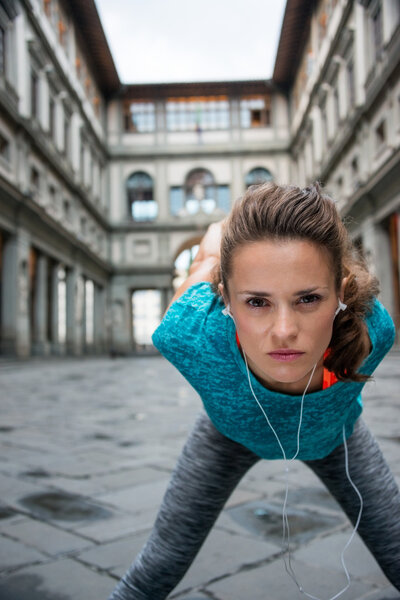 Fitness woman stretching near uffizi gallery in florence, italy