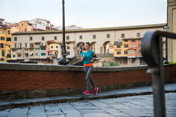 イタリア、フィレンツェのヴェッキオ橋近くジョギング フィットネス女性 — ストック写真