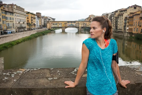 フィットネス女性、フィレンツェのヴェッキオ橋の前に立ってそれ — ストック写真