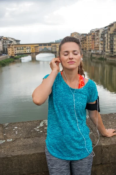 Fitness vrouw luisteren muziek voor ponte vecchio in flore — Stockfoto