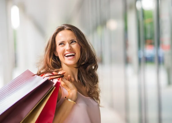 Bruinharige, gelukkig, lachende vrouw bedrijf shopping tassen — Stockfoto