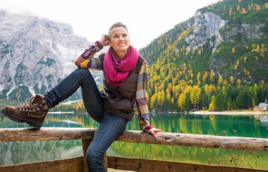 Gülümseyen kadın uzun yürüyüşe çıkan kimse Lake Bries sonbahar renkleri ile poz
