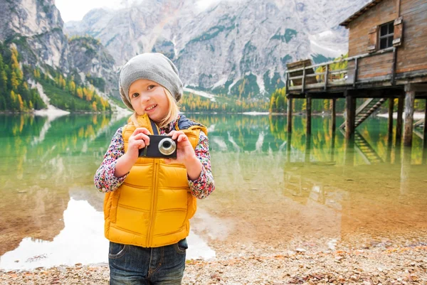 Young blonde girl on shores of Lake Bries holding a camera — Stock Photo, Image