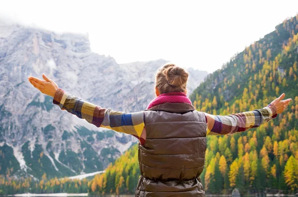 Woman hiker opening arms in joy against autumn background — Stock Photo, Image