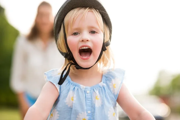 Blond, blåögd, leende och glad flicka klädd i en cykel hjälm — Stockfoto