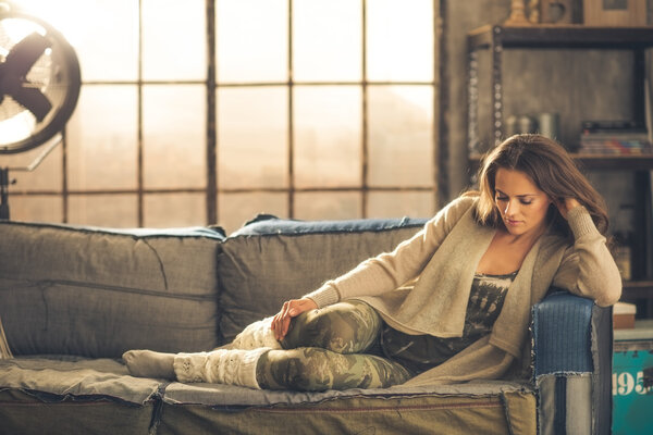 Woman sitting relaxing on a sofa dressed comfortably
