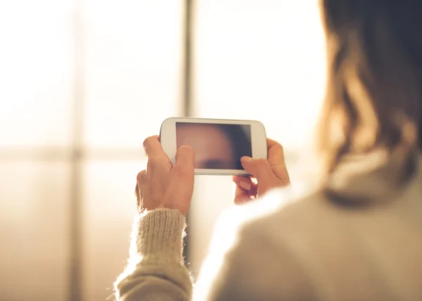 Nahaufnahme einer Frau, die ihr Handy von hinten hält — Stockfoto