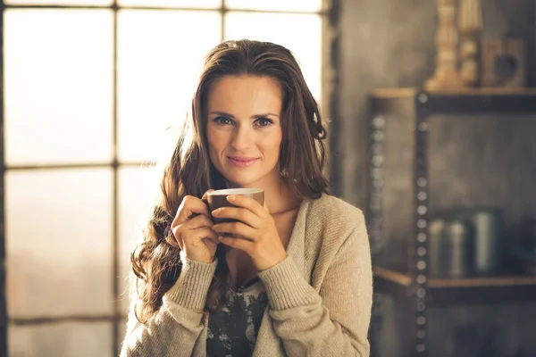 Head and shoulder shot of woman holding cup in loft apartment — Stock Photo, Image