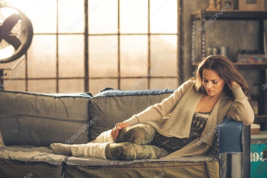 Woman sitting relaxing on a sofa dressed comfortably