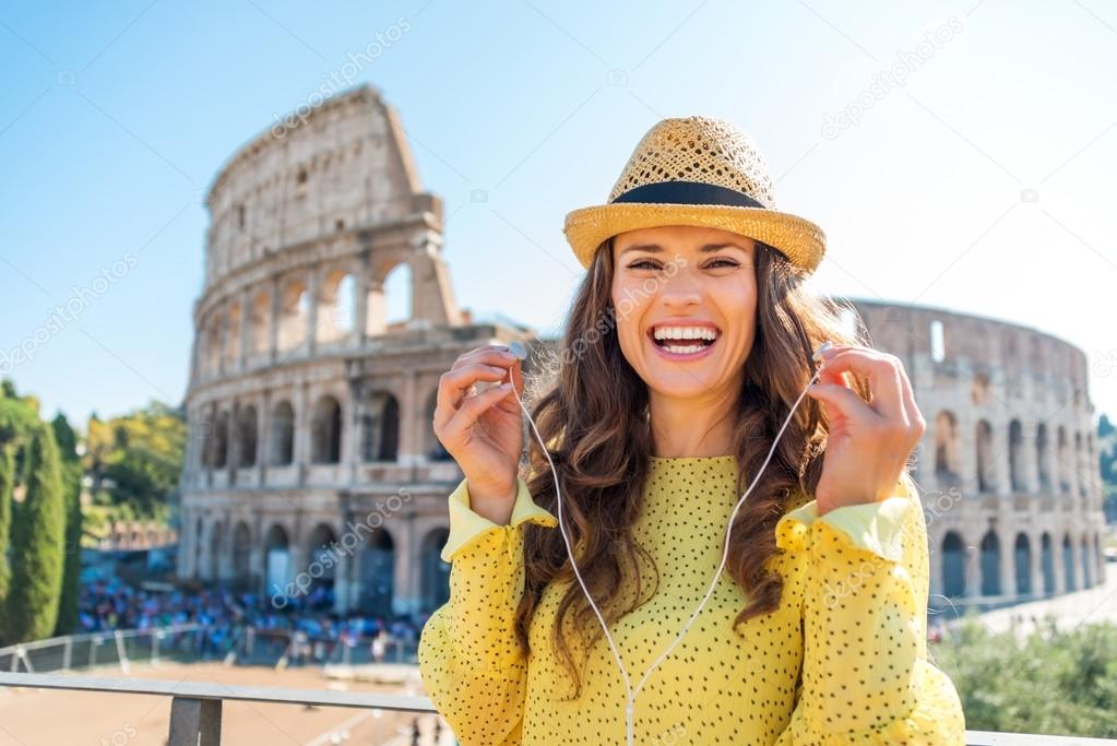 Woman standing near Colosseum in Rome removing earbuds
