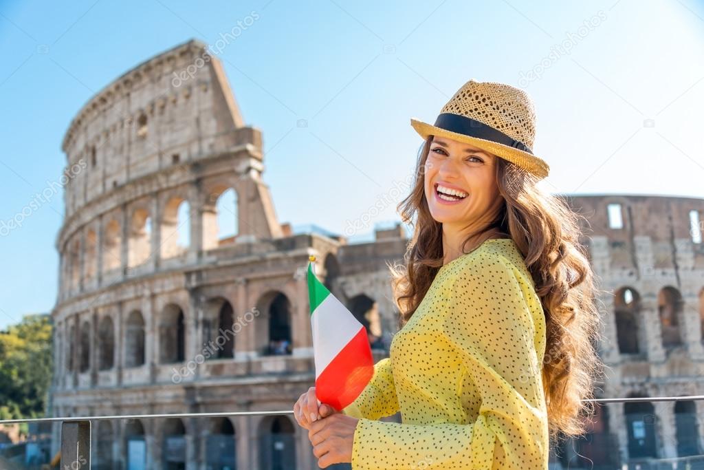 Woman holding flag and smiling at Colosseum in Rome