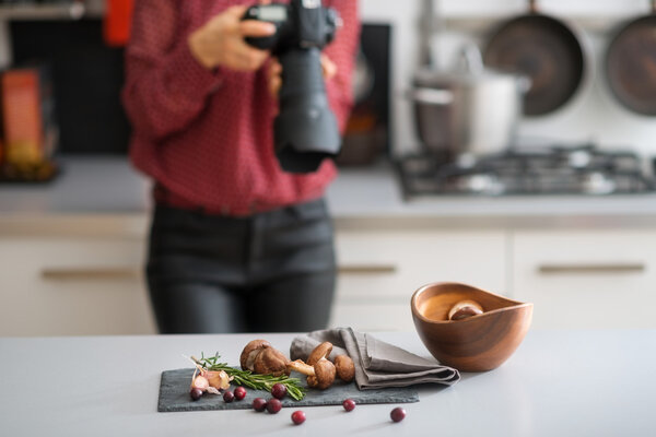 Woman photographer focuses lens autumn fruits and vegetables