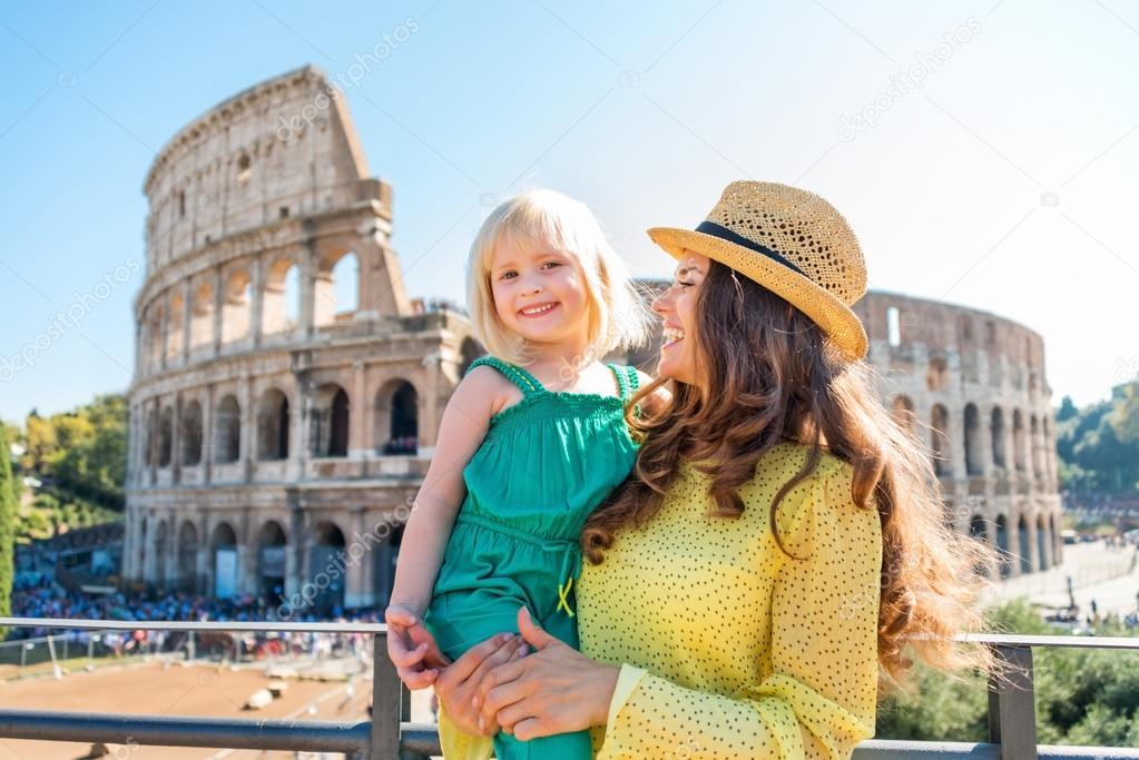 Smiling mother and daughter with Colosseum in background