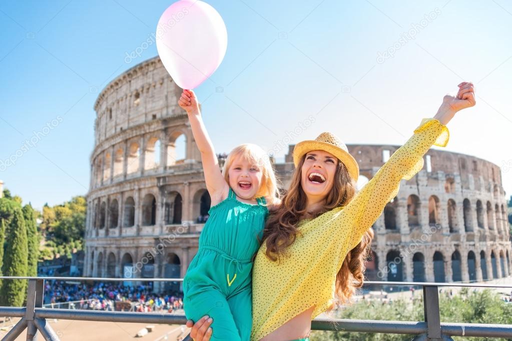 Cheering mother and daughter with pink balloon at Colosseum