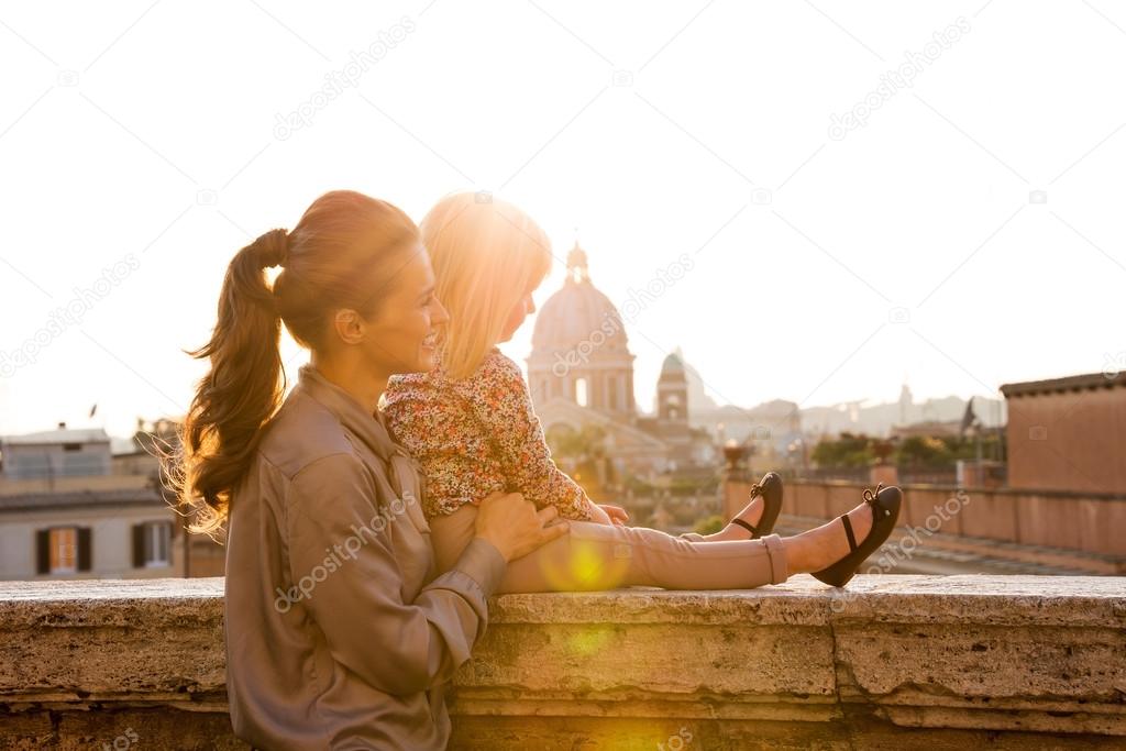 Mother and daughter in profile at sunset with St. Peter's