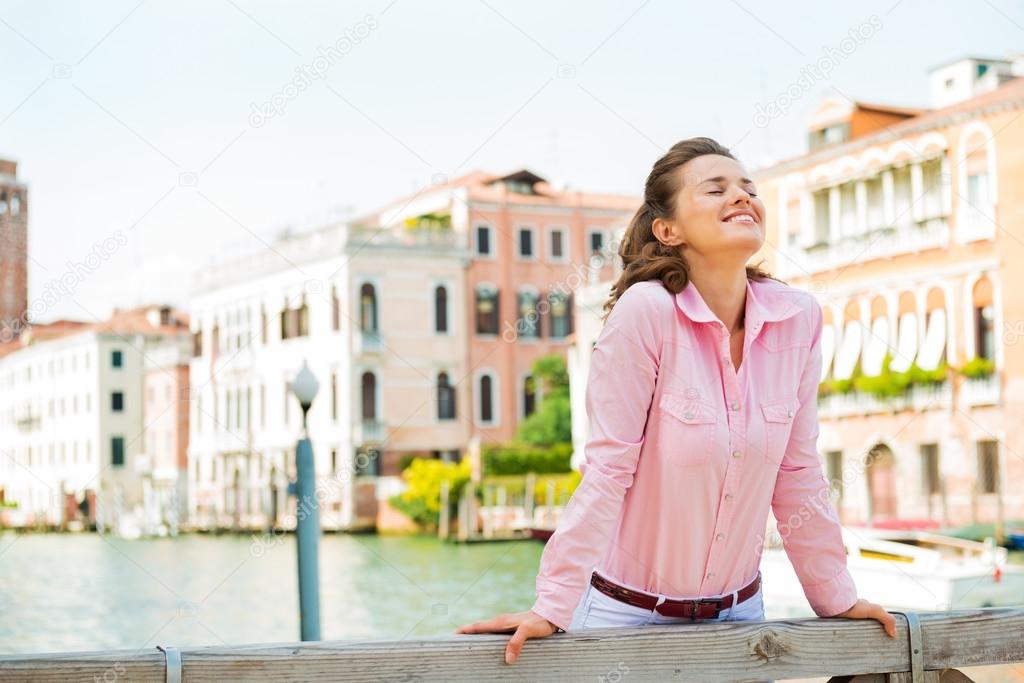 Happy woman smiling up to the sun in Venice