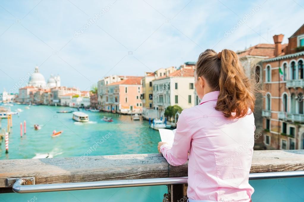 Woman from behind reading map above Grand Canal in Venice