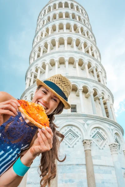 Woman biting slice of pizza by Leaning Tower of Pisa — Stock Photo, Image