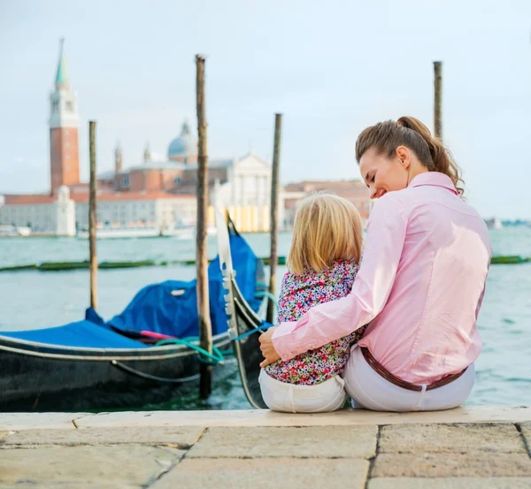 Moeder en dochter zit in de buurt van gondels in Venetië — Stockfoto