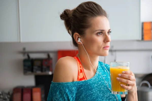 Closeup of woman in profile wearing workout gear holding juice — Stock Photo, Image