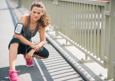 kentsel ortamda yaz aylarında kaldırıma diz çökmüş kadın runner