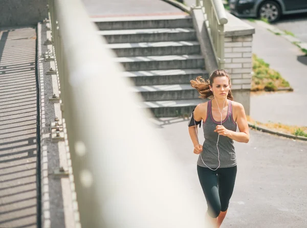 Woman jogger in the zone running along sidewalk — Stock Photo, Image