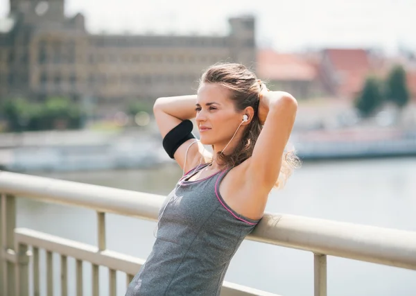 Woman leaning back with hands behind head, relaxing on bridge — Stock Photo, Image