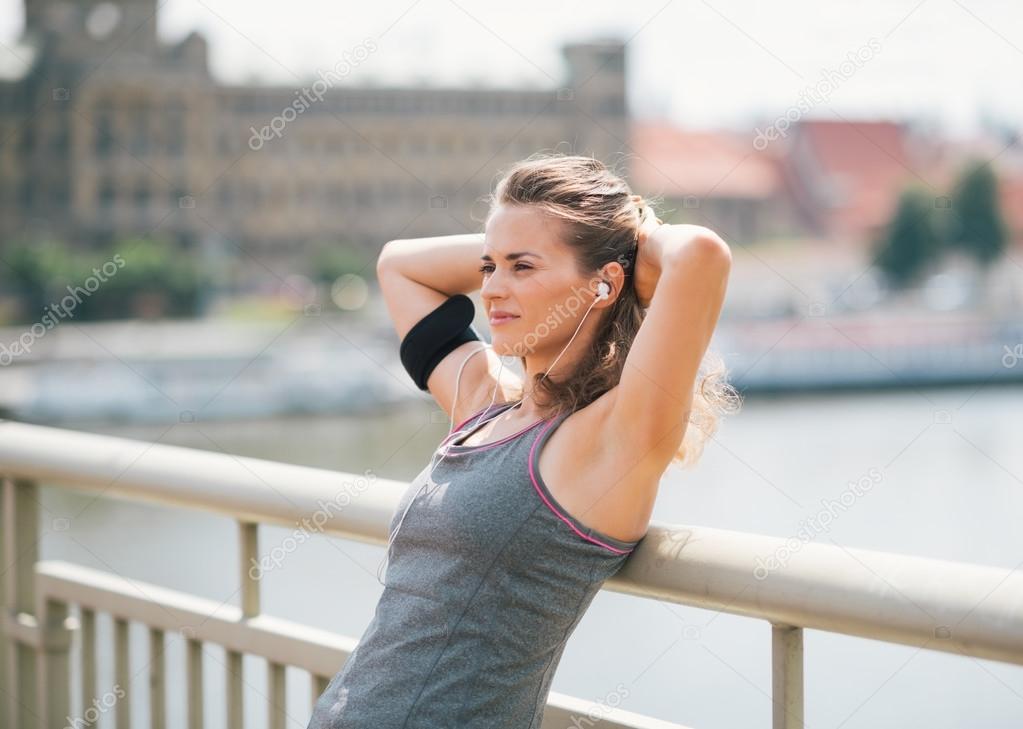 Fitness. Woman Doing Workout Exercise On Street. Beautiful Fit Girl Wearing  Fitness Tracker, Headphones And Armband Phone Case Stretching Her Long Legs  Outdoors. Sports Devices. High Resolution Stock Photo, Picture and Royalty