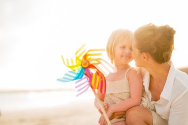 Mutlu anne ve bebek kız için renkli yel değirmeni ile portre