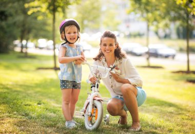 Mutlu anne ve bebek kız bisiklet ile portre