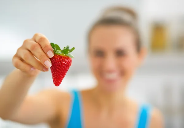 Gros plan sur heureux jeune femme montrant fraise — Photo